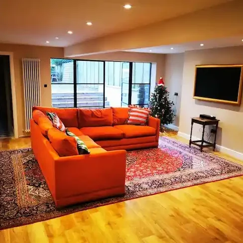 basement conversion Leeds living room with engineered hardwood flooring and large windows